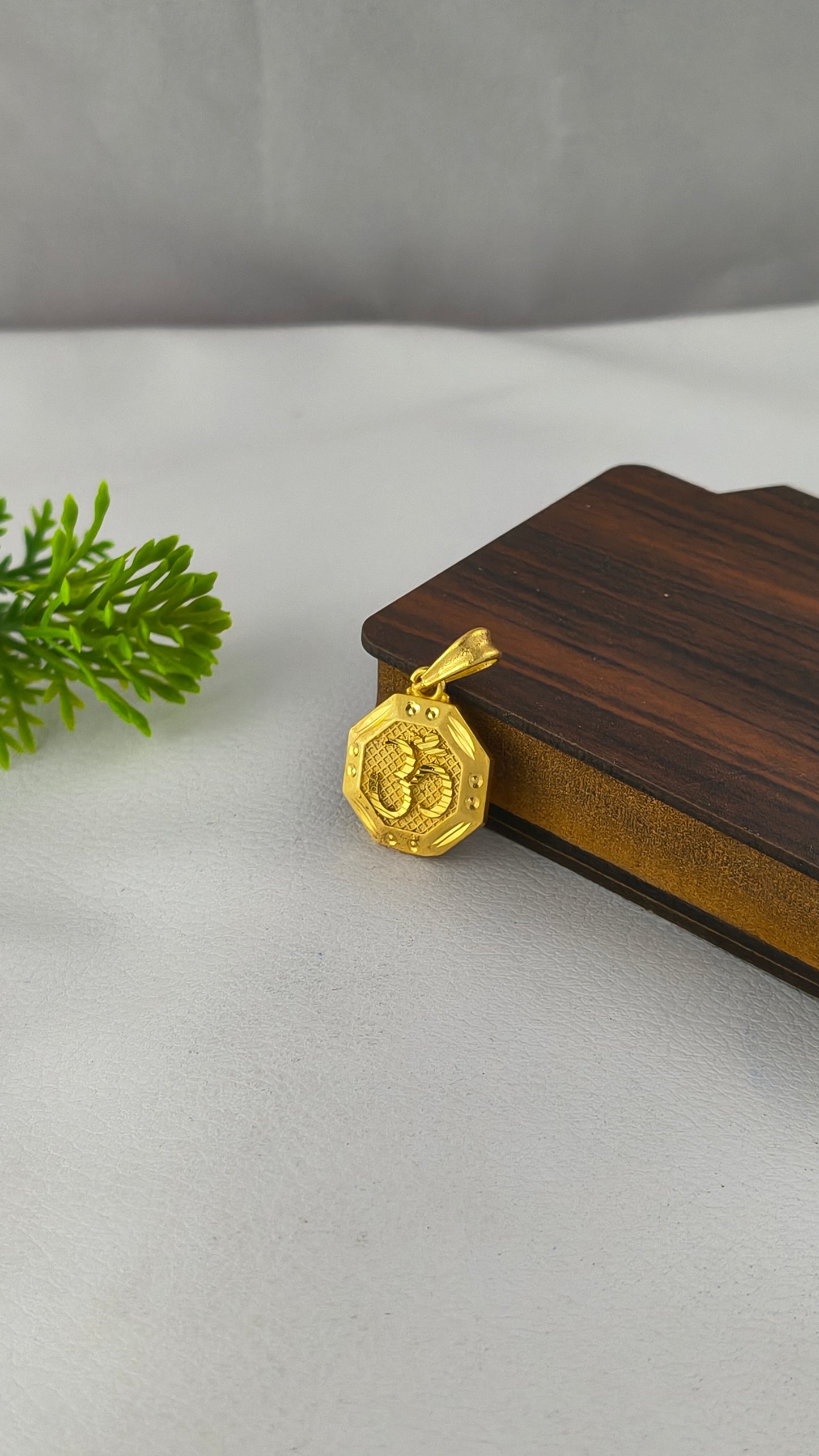 An Octagonal Gold Om pendant, Highly Gold Plated .